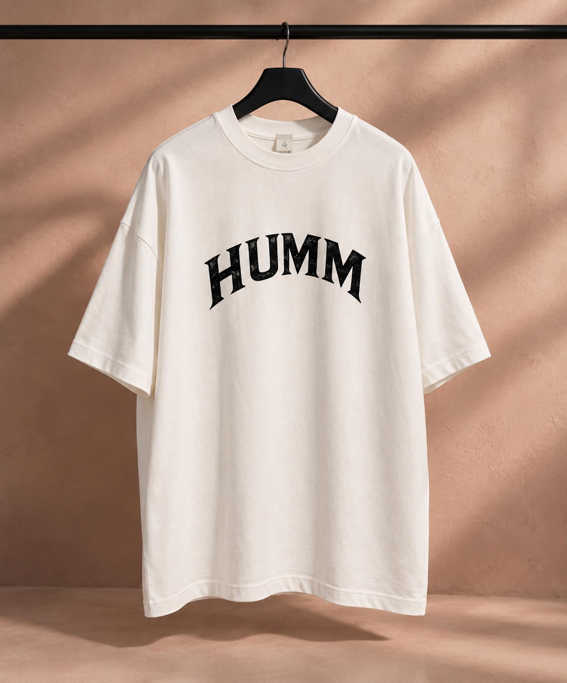The Hourglass, off-white oversized tee met het HUMM-boogje in zwart op de voorkant